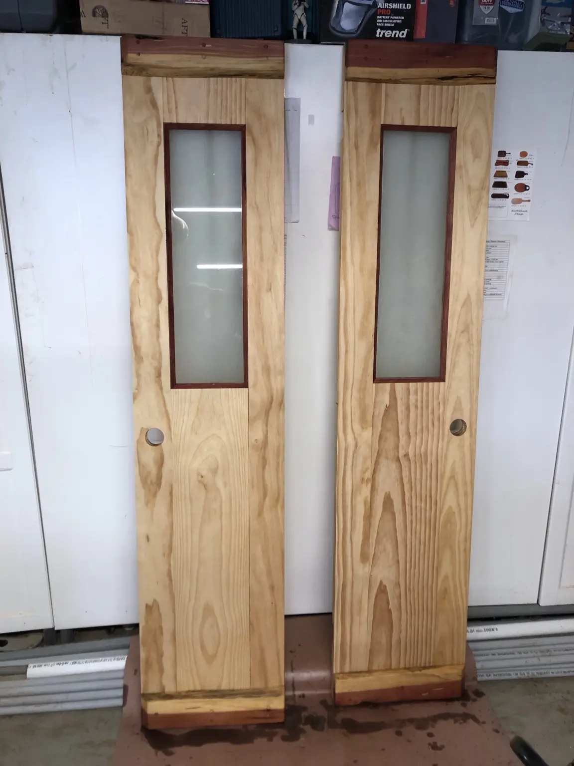 Pair of custom wood doors with frosted glass panels before installation