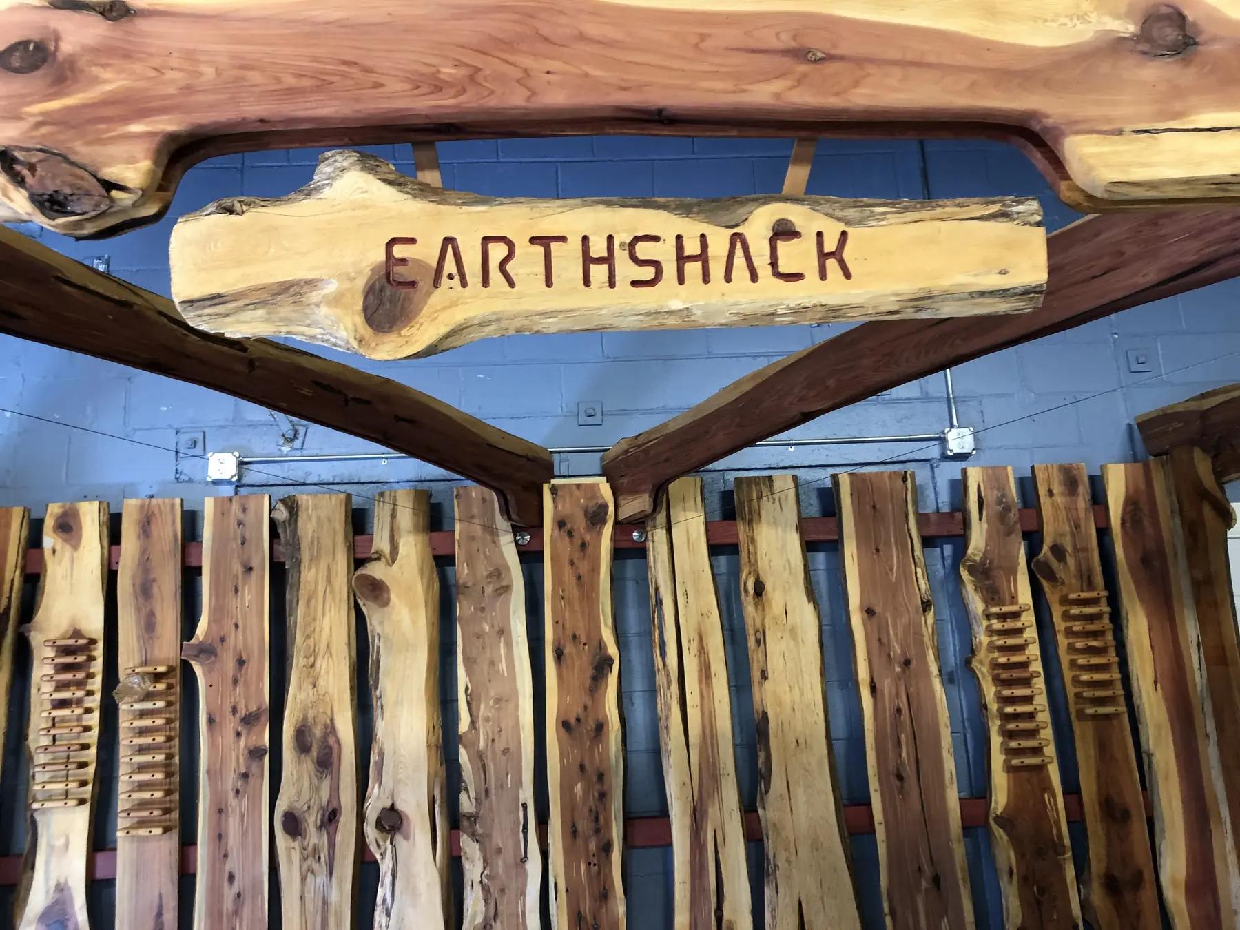 Close-up of the carved Earth Shack sign on the custom live-edge display