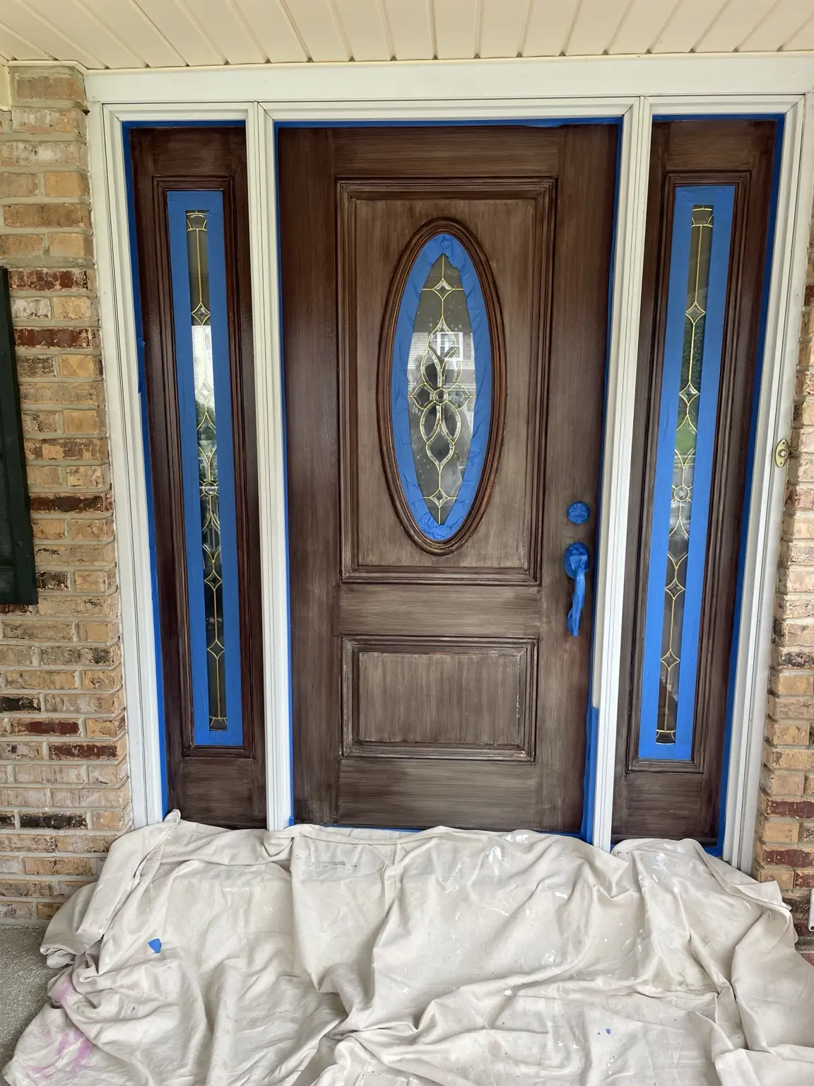 Front door and matching sidelights masked and prepared during refinishing