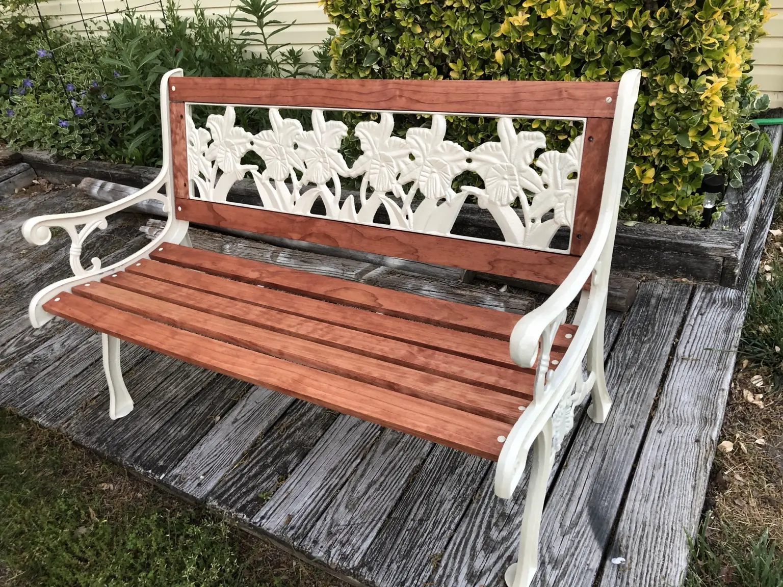 Restored garden bench with refinished wood slats and painted metal frame