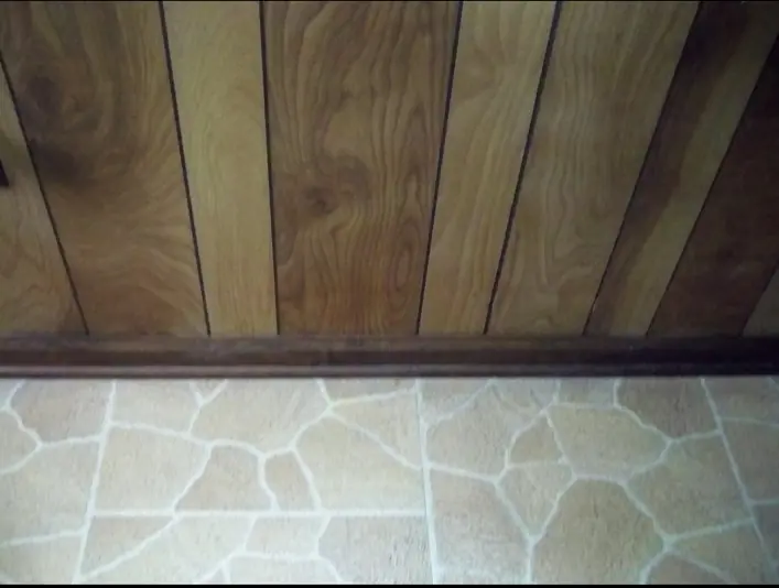 Wood paneling restored after the adhesive streak was removed and the grain was repaired
